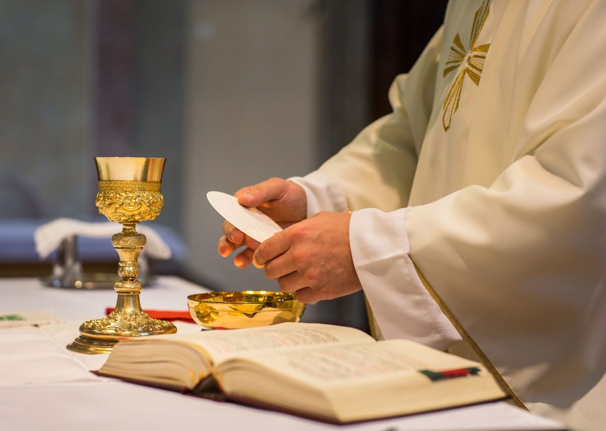 Mensagem dia Padre 2025. A imagem mostra um sacerdote consagrando a eucaristia durante a missa.